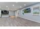 Open-concept living space with wood flooring, modern lighting, a large window, and adjacent kitchen at 275 Lakeshore Dr, Davenport, FL 33837