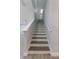 Stairway leading to the upper level with white risers and stringers and wood treads at 275 Lakeshore Dr, Davenport, FL 33837