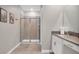 Bright bathroom with a walk-in shower featuring tiled walls and a vanity with a stone countertop at 2821 Bookmark Dr, Kissimmee, FL 34746