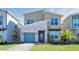 Inviting home featuring a stone accent wall, a well-manicured lawn, and a charming, colored garage door at 2821 Bookmark Dr, Kissimmee, FL 34746