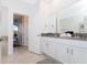 Bright bathroom features a double sink vanity with gray countertops, white cabinets and tile floors at 2836 Simile St, Kissimmee, FL 34746