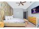 Bright bedroom with floral wallpaper, white linens, wooden furniture, and a ceiling fan at 2836 Simile St, Kissimmee, FL 34746