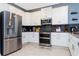 Well-equipped kitchen with stainless steel refrigerator, double oven, and ample cabinet space at 2836 Simile St, Kissimmee, FL 34746