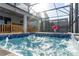 Sparkling pool and spa in a screened enclosure, featuring a basketball hoop and outdoor seating area at 2836 Simile St, Kissimmee, FL 34746