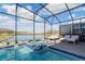 Beautiful pool and spa area in a screened enclosure, with views of the lake and surrounding landscape at 2836 Simile St, Kissimmee, FL 34746