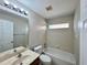 Neutral bathroom features a shower-over-tub and large mirror over the vanity sink at 3049 Buckeye Pointe Dr, Winter Haven, FL 33881