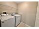 A neutral laundry room has a washing machine and dryer along with shelving at 3049 Buckeye Pointe Dr, Winter Haven, FL 33881