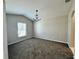 Cozy living room with a chandelier, neutral paint, carpet, and a large window at 3049 Buckeye Pointe Dr, Winter Haven, FL 33881