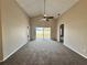 Expansive living room featuring sliding glass doors, a ceiling fan, and neutral carpeting at 3049 Buckeye Pointe Dr, Winter Haven, FL 33881