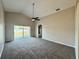Carpeted living room with high ceilings, ceiling fan, and sliding door access to the backyard at 3049 Buckeye Pointe Dr, Winter Haven, FL 33881