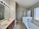 The ensuite features a double sink vanity, tub, and glass enclosed shower at 3049 Buckeye Pointe Dr, Winter Haven, FL 33881