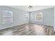 Bright bedroom with gray wood floors and large windows with a view of the outdoors at 3813 Goldenglow Dr, Orlando, FL 32828