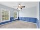 Carpeted bedroom with blue accent wall and large windows providing natural light at 3813 Goldenglow Dr, Orlando, FL 32828