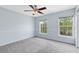 Cozy bedroom featuring carpet, two windows and light blue walls with white trim at 3813 Goldenglow Dr, Orlando, FL 32828