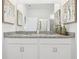 Bathroom vanity featuring double sinks, granite countertops, decorative paintings, and white cabinets at 439 Shoreview Sands Ave, Mascotte, FL 34753