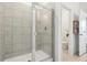 Tiled shower with a glass door in a bright bathroom featuring a toilet and a white door at 439 Shoreview Sands Ave, Mascotte, FL 34753