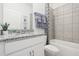 Bathroom featuring a granite countertop, white cabinets, and a shower with tile surround at 439 Shoreview Sands Ave, Mascotte, FL 34753
