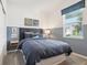Stylish bedroom with modern decor, a large window, and a comfortable blue bedspread at 439 Shoreview Sands Ave, Mascotte, FL 34753
