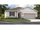 Charming one-story home featuring a two-car garage, classic shutters, manicured lawn and stone accents at 439 Shoreview Sands Ave, Mascotte, FL 34753