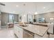 Open kitchen with granite countertops, stainless steel appliances, and an adjacent living room at 439 Shoreview Sands Ave, Mascotte, FL 34753