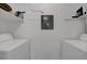 This laundry room features a washer and dryer, shelving and a neutral color palette at 4400 Thornbriar Ln # 104, Orlando, FL 32822