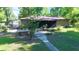 A cozy backyard with a screened porch, patio area, and lush greenery providing a relaxing outdoor space at 4519 Se 140Th Pl, Summerfield, FL 34491