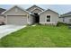 Beige single-Gathering home featuring an attached two-car garage, well-manicured lawn, and neutral-tone exterior paint at 4586 Se 25Th Loop, Ocala, FL 34480