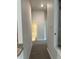 Bright hallway with carpeted floors leading to a bathroom, showcasing the home's well-lit interior at 4586 Se 25Th Loop, Ocala, FL 34480