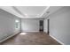 Spacious room featuring wood floors, a tray ceiling, and ample natural light at 4905 Pall Mall E St, Kissimmee, FL 34758