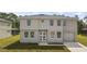 Two-story home boasts a symmetrical design with a well-manicured lawn and attached one-car garage at 4905 Pall Mall E St, Kissimmee, FL 34758