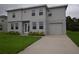 Inviting two-story home featuring a well-maintained lawn, attached garage, and neutral gray color scheme at 4905 Pall Mall E St, Kissimmee, FL 34758