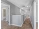 Hallway with wood floors, neutral paint and open doorways to adjoining rooms at 4905 Pall Mall E St, Kissimmee, FL 34758