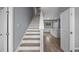 Bright interior showcasing stairs with wood treads, leading into an open-concept kitchen and living area at 4905 Pall Mall E St, Kissimmee, FL 34758