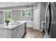 Bright kitchen features white cabinets, quartz countertops, stainless steel appliances, and views to outdoors at 4905 Pall Mall E St, Kissimmee, FL 34758