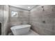 Modern bathroom featuring a luxurious standalone soaking tub and tiled wall at 4905 Pall Mall E St, Kissimmee, FL 34758