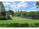 A lush green yard with a view of pond behind a black metal fence and mature trees at 506 Harbor Winds Ct, Winter Springs, FL 32708