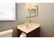 This bathroom features a vanity with a sink, toilet, light fixture, and window with blinds at 506 Harbor Winds Ct, Winter Springs, FL 32708