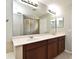 Bathroom featuring a double sink vanity with wood cabinets and a large mirror at 506 Harbor Winds Ct, Winter Springs, FL 32708