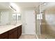 Bright bathroom featuring a glass-enclosed shower and double sink vanity with wood cabinets at 506 Harbor Winds Ct, Winter Springs, FL 32708