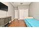 This bedroom features a large wardrobe, gray walls, hardwood floors, and a mounted television at 506 Harbor Winds Ct, Winter Springs, FL 32708