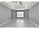 The bedroom boasts abundant light, enhanced by a ceiling fan and stylish gray-toned flooring for a modern aesthetic at 506 Harbor Winds Ct, Winter Springs, FL 32708