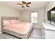 This is a bedroom with gray wood floors, a ceiling fan, mounted tv, window, and dresser at 506 Harbor Winds Ct, Winter Springs, FL 32708