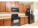 Kitchen with wooden cabinets, black appliances, and beige countertops at 506 Harbor Winds Ct, Winter Springs, FL 32708