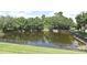 An overhead shot of a fenced in tranquil pond surrounded by a beautiful mature tree line on a sunny day at 506 Harbor Winds Ct, Winter Springs, FL 32708