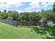View of a fenced in tranquil pond surrounded by a beautiful mature tree line on a sunny day at 506 Harbor Winds Ct, Winter Springs, FL 32708