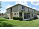 Back corner view of the house with screened in patio area, windows, and trimmed hedges at 506 Harbor Winds Ct, Winter Springs, FL 32708
