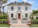 Elegant white two-story home with symmetrical windows, shutters, and landscaped front yard at 541 W Canton Ave, Winter Park, FL 32789