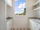 Well-lit laundry room with custom cabinets, open shelving, and charming patterned tile flooring at 541 W Canton Ave, Winter Park, FL 32789