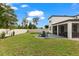 Spacious backyard featuring a patio, dining set, lush lawn, and white fencing, ideal for outdoor enjoyment at 5458 Carrara Ct, St Cloud, FL 34771