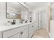 Bright bathroom with double sinks, white cabinets, black hardware, and a tiled shower at 5458 Carrara Ct, St Cloud, FL 34771